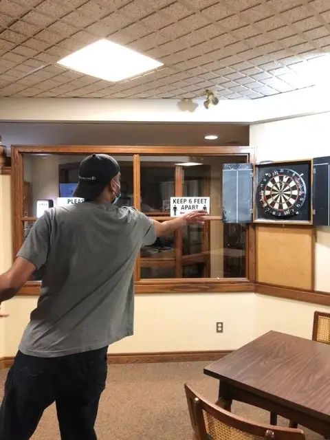 a gentleman throwing a dart in our bar lounge room